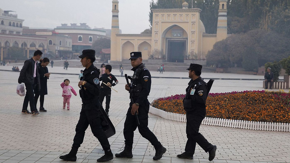 Uighur security personnel patrol near the Id Kah Mosque in Kashgar in western China's Xinjiang region in this 2017 file photo. (Ng Han Guan / Associated Press)