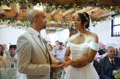 Bride and groom exchanging rings during wedding ceremony at The Talbot Ripley Surrey