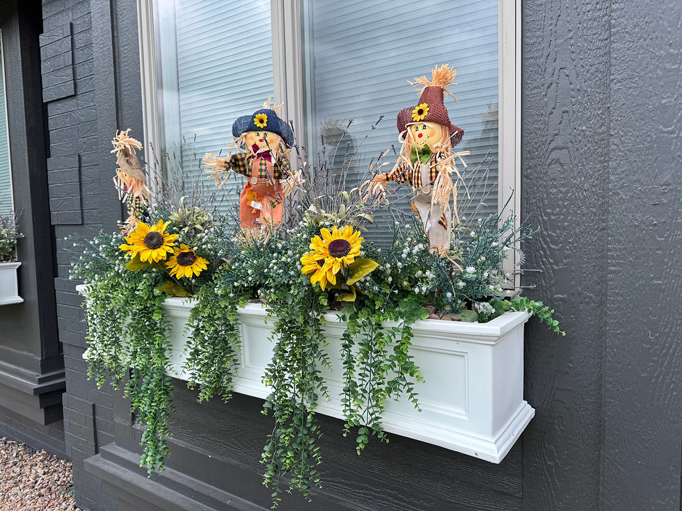 A window box with fall scarecrows