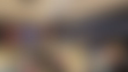 Menschen sitzen in einem Musik und Produktionsstudio im Kreis, folgen einer Präsentation und unterhalten sich.