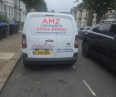 White van with AMZ Locksmith 24/7 Call Out, parked on street.