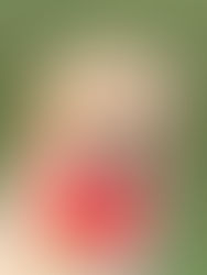 Golden retriever holding a red first-aid kit with text in its mouth, sitting on green grass, conveying a helpful mood.