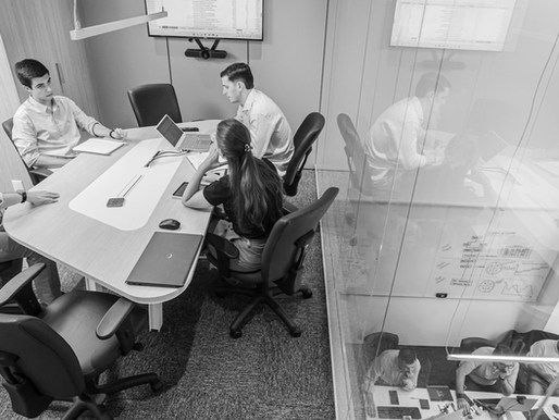 Advisory team conducting an exit readiness working session in a glass-walled conference room.