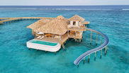 An overwater villa at Soneva Fushi with a waterslide curving into the lagoon