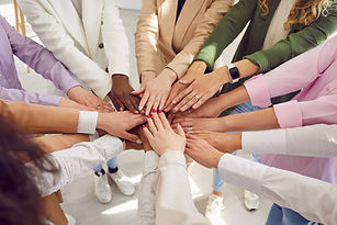 Team of young, diverse, mixed race, multiethnic business women all together holding their