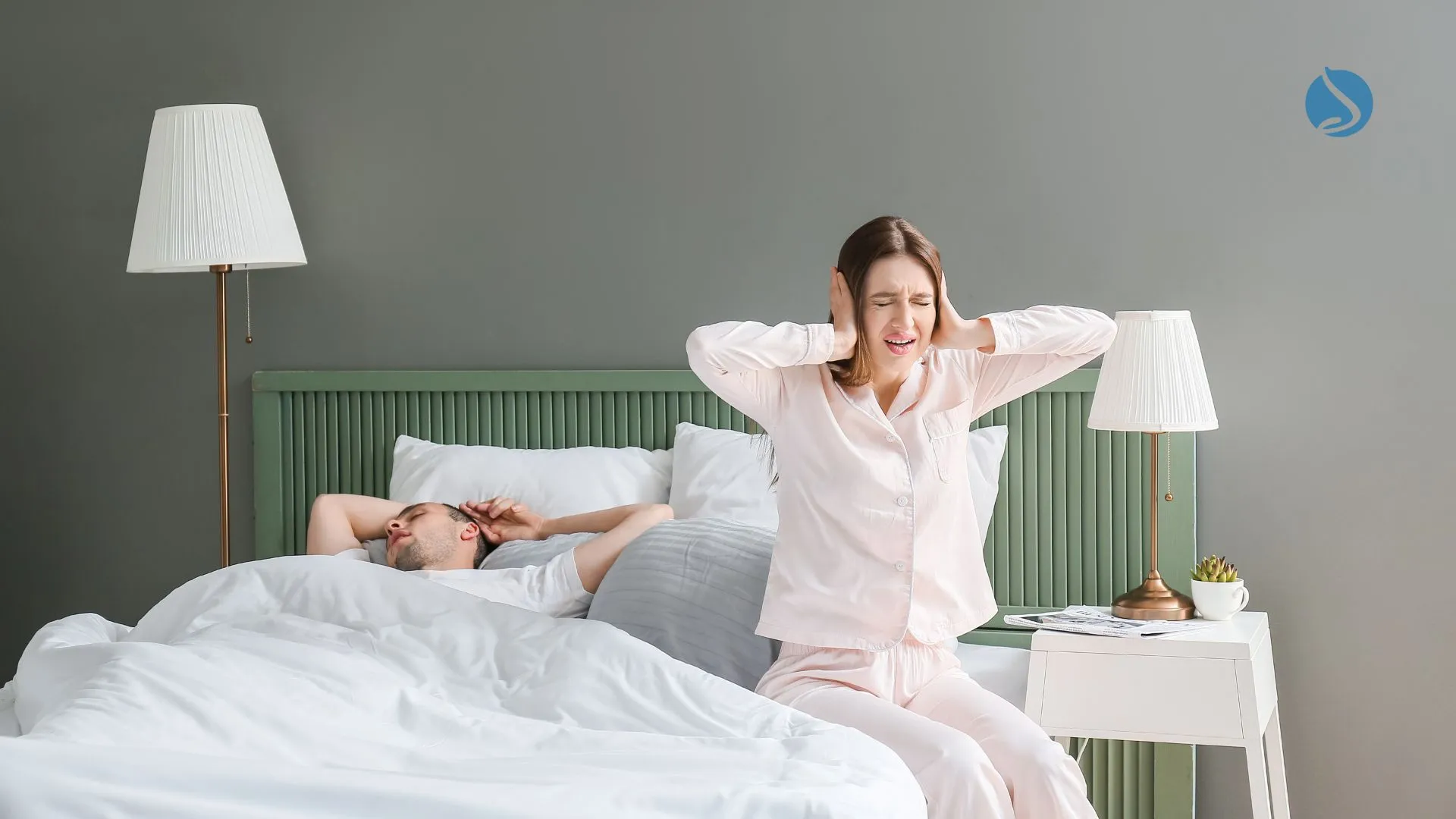 woman covering ears, sitting on the edgs of the bed