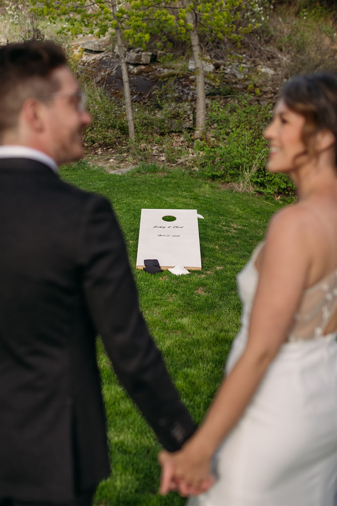 bride and groom playing Penticton wedding rentals, lawn game rentals, personalized cornhole on wedding day in Okanagan
