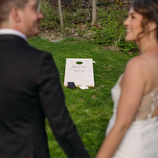 bride and groom playing Penticton wedding rentals, lawn game rentals, personalized cornhole on wedding day in Okanagan
