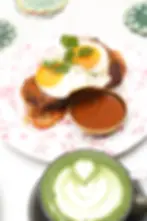 A plate of steak and eggs with a side of sauce at Café Bastille, featuring two fried eggs on top of a steak