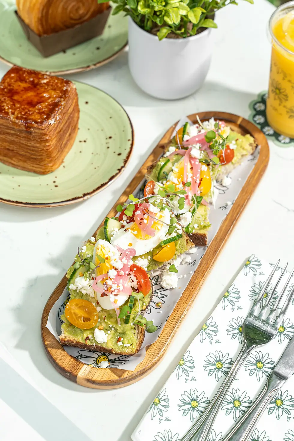 Avocado toast topped with eggs, tomatoes, and feta at Café Bastille, walk-in only brunch Fort Lauderdale