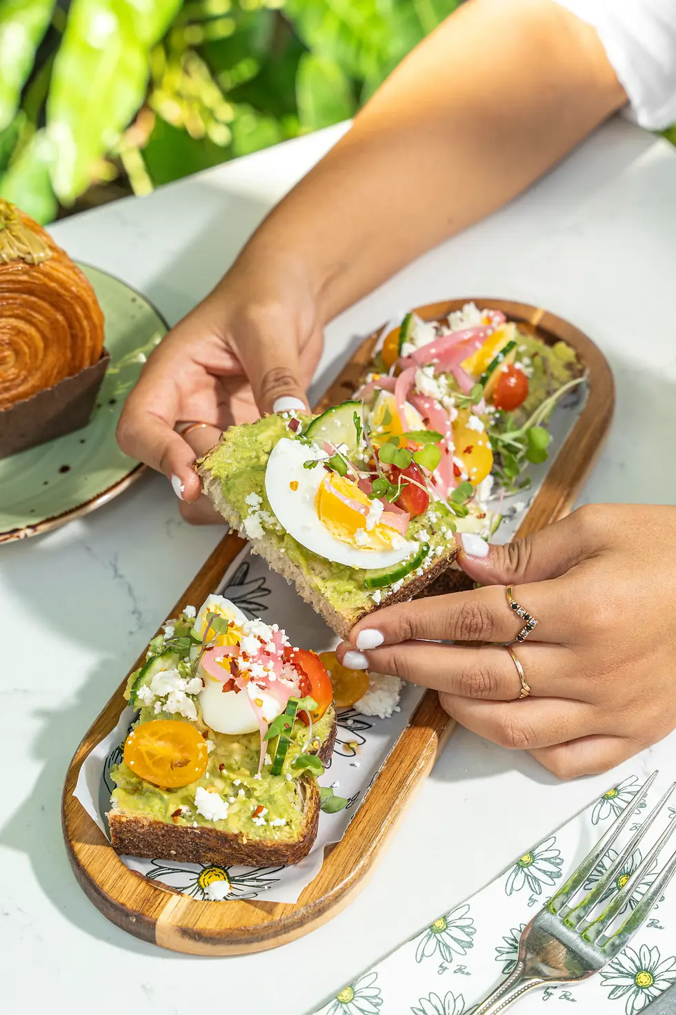 Avocado toast with feta, egg, and tomatoes at a brunch restaurant in Miami.