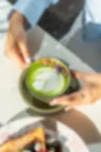 A vibrant matcha latte with floral garnish and latte art at a brunch restaurant Miami
