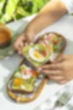 Avocado toast with organic egg, heirloom tomatoes, cucumber, and feta on sourdough.