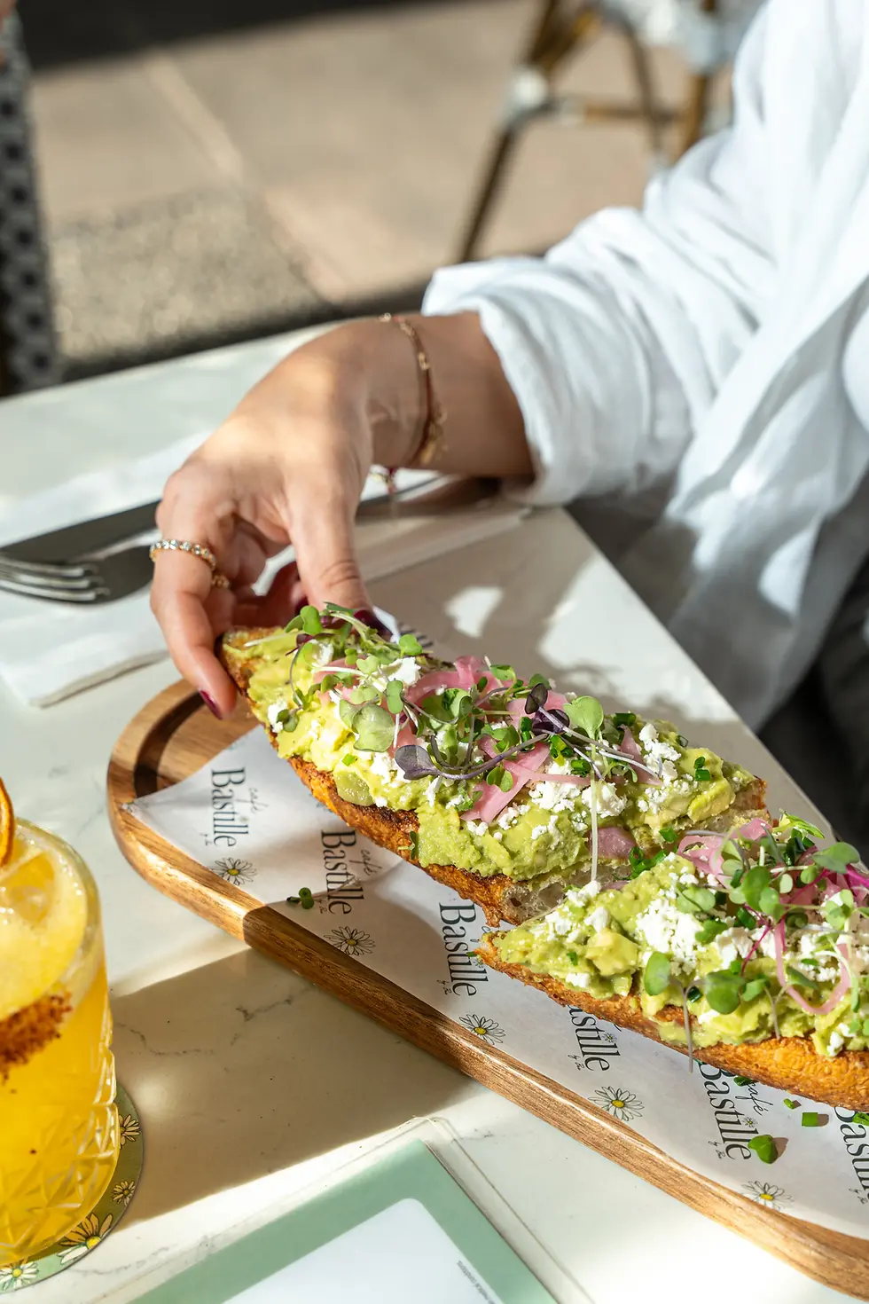 Avocado tartine topped with feta, microgreens, and pickled onions, served at the best brunch spot in Miami Beach.