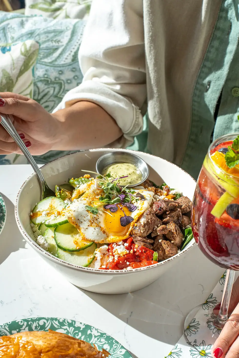 Steak and eggs bowl with avocado, feta, red peppers, and cilantro aioli.