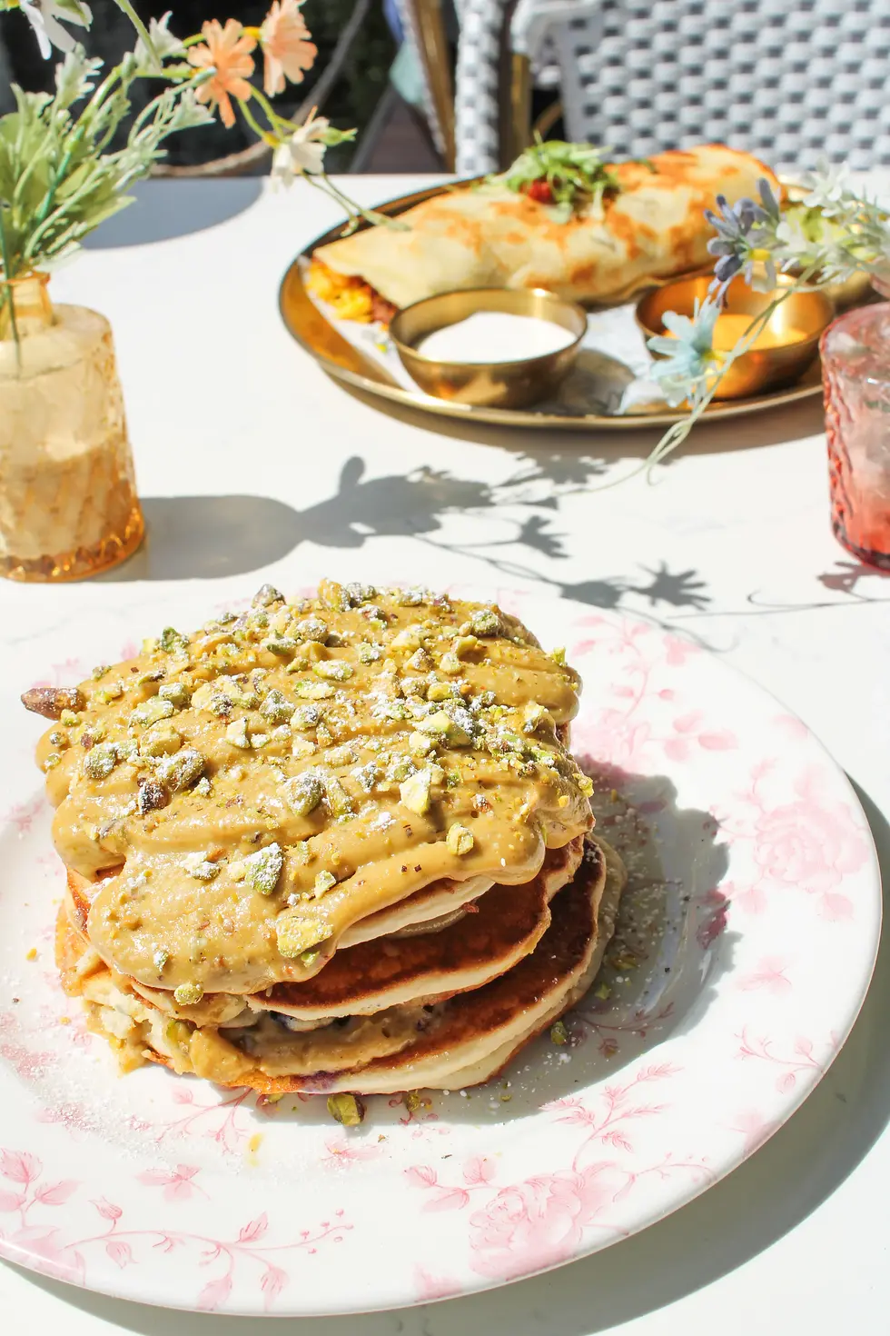 Pistachio pancakes with white chocolate chips, pistachio cream, and crumbs