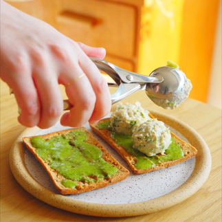 Scooping vegan tuna mousse (tun-ah mousse) onto the bread
