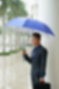 asian-businessman-standing-street-with-umbrella-rain.jpg