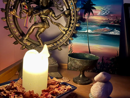 a shrine with a candle and bowl and statue