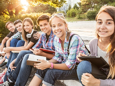 group of young students with books and gadgets sit on the steps in the park_edited.jpg