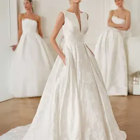 Her unique silhouette is perfect for the modest bride looking for something a little different. Her dramatic A-Line silhouette crafted from a floral textured jacquard, reveals soft botanical designs. Her high neckline is accented with a structured plunging V, finishing at mid bust, for a tasteful take on the plunge neckline trend. Brides will love her pockets, hidden between natural gathers in her full skirt.