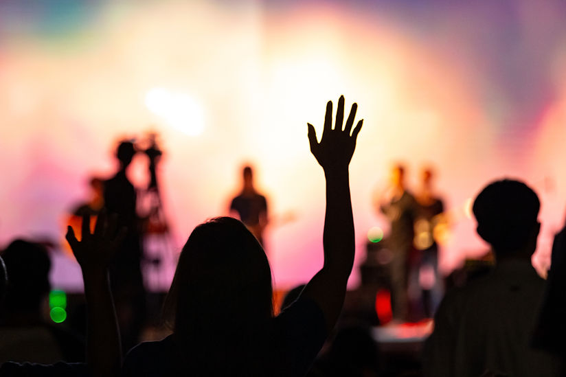 Background of Sunday service in church_ Blurred silhouette woman raised hand to worship Go