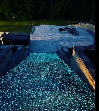 Illuminated stone walkway and patio entrance by Yard Shark Lawn Care