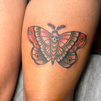 Color traditional deaths head moth or butterfly on the thigh