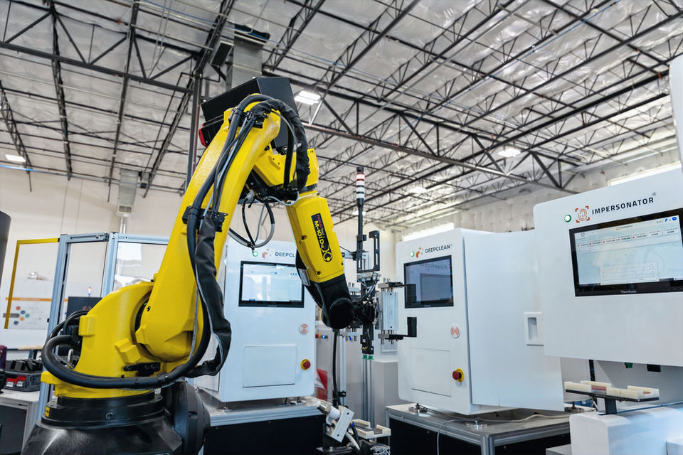 Robotic arm automating device testing and sorting in a reverse logistics facility using AI and machine vision