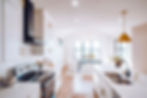 Bright modern kitchen featuring expansive windows that flood the space with natural light and sleek white cabinetry.