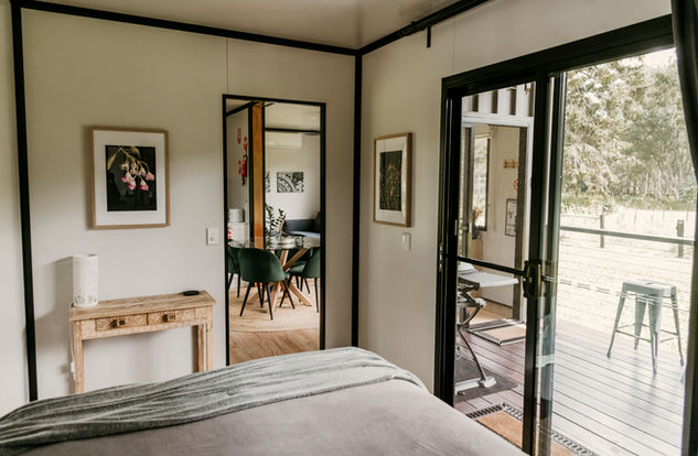 Queen bedroom with sliding glass doors to deck at Contained in Nimbin.