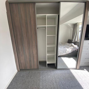 Closet with open door, shelves, and a mirror reflecting the room.