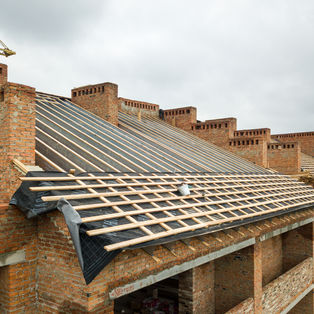 Brick building under construction with roofing materials and roofing South West