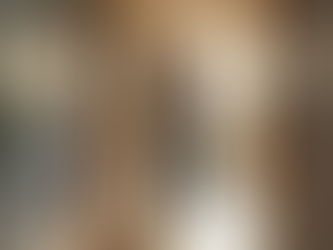 Elderly man walking with crutches down a sunlit hallway, light streaming through windows. Warm tones and a potted plant are visible.