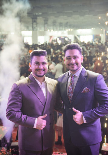 Abhishek Gagneja and his brother Aditya celebrating on the main stage in front of a massive crowd at the 2025 Bharat Pro Show in Mumbai.