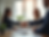 A friendly, professional advisor shaking hands with a client in a bright, welcoming office