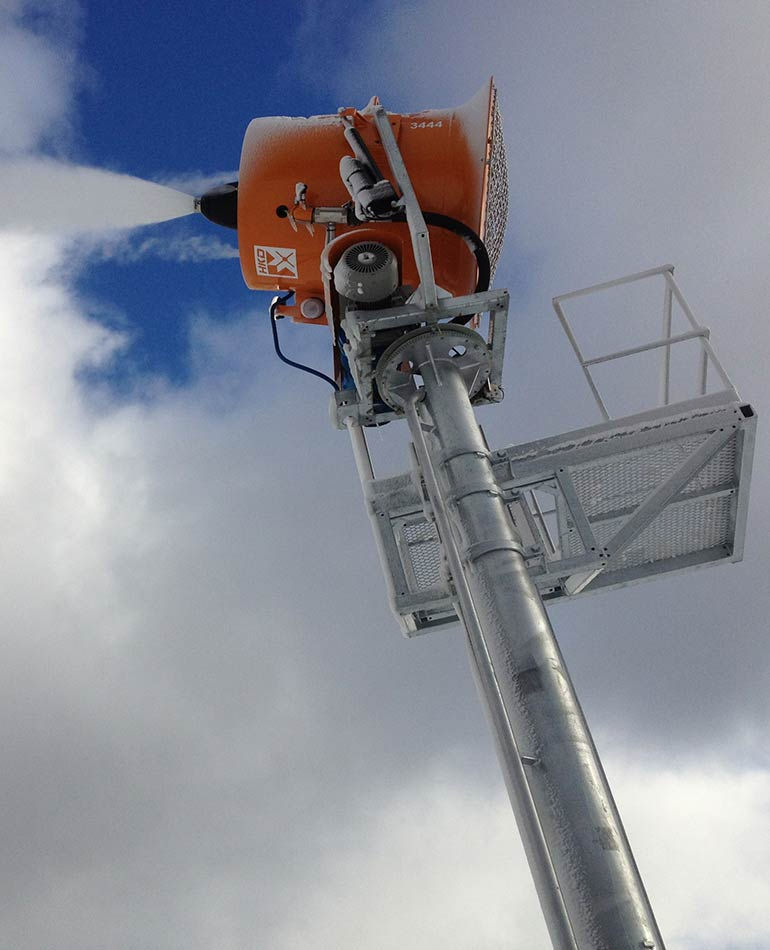 HKD fan snowgun producing snow from a tower mount.