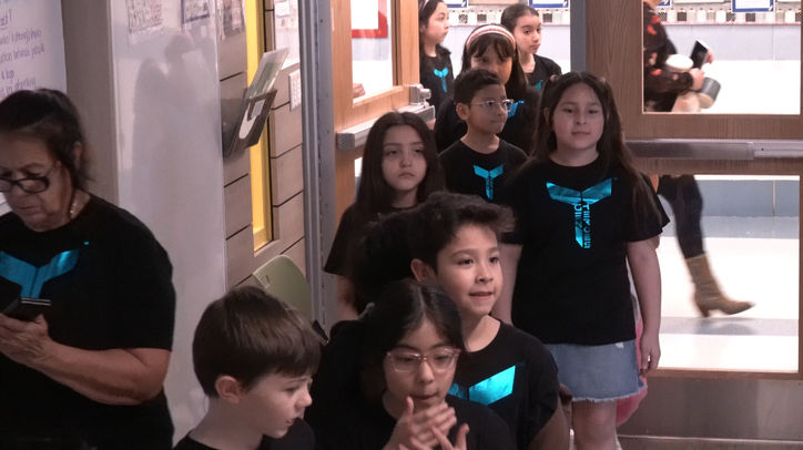 Students wearing custom t-shirts provided by TMoore The Motivator entering school assembly building unity and team mindset