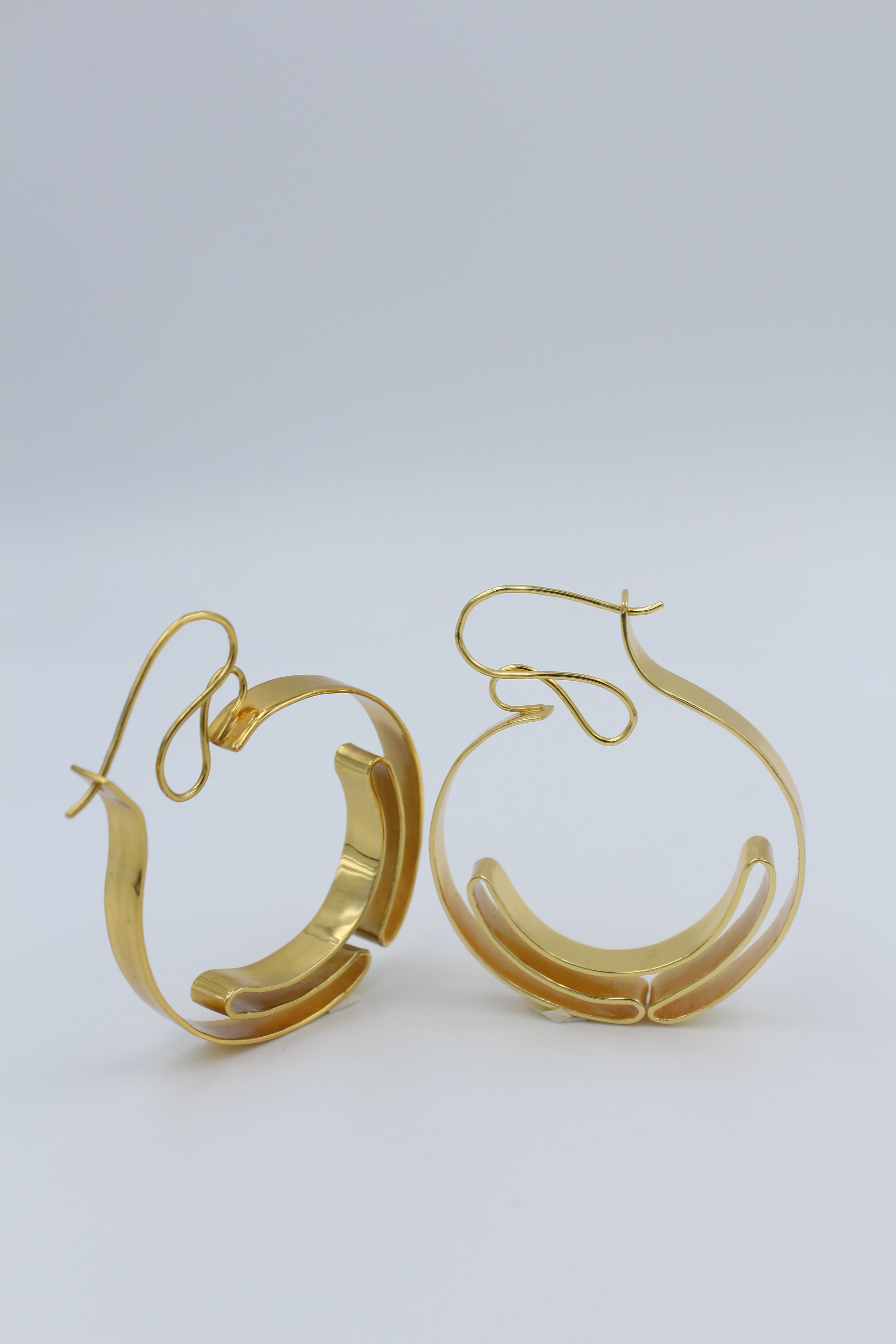 Minimalist ballet-inspired earrings featuring delicate, ribbon-like curves — elegant, dainty jewelry evoking ballerina grace and lightweight movement, perfect for everyday chic or feminine fashion trends