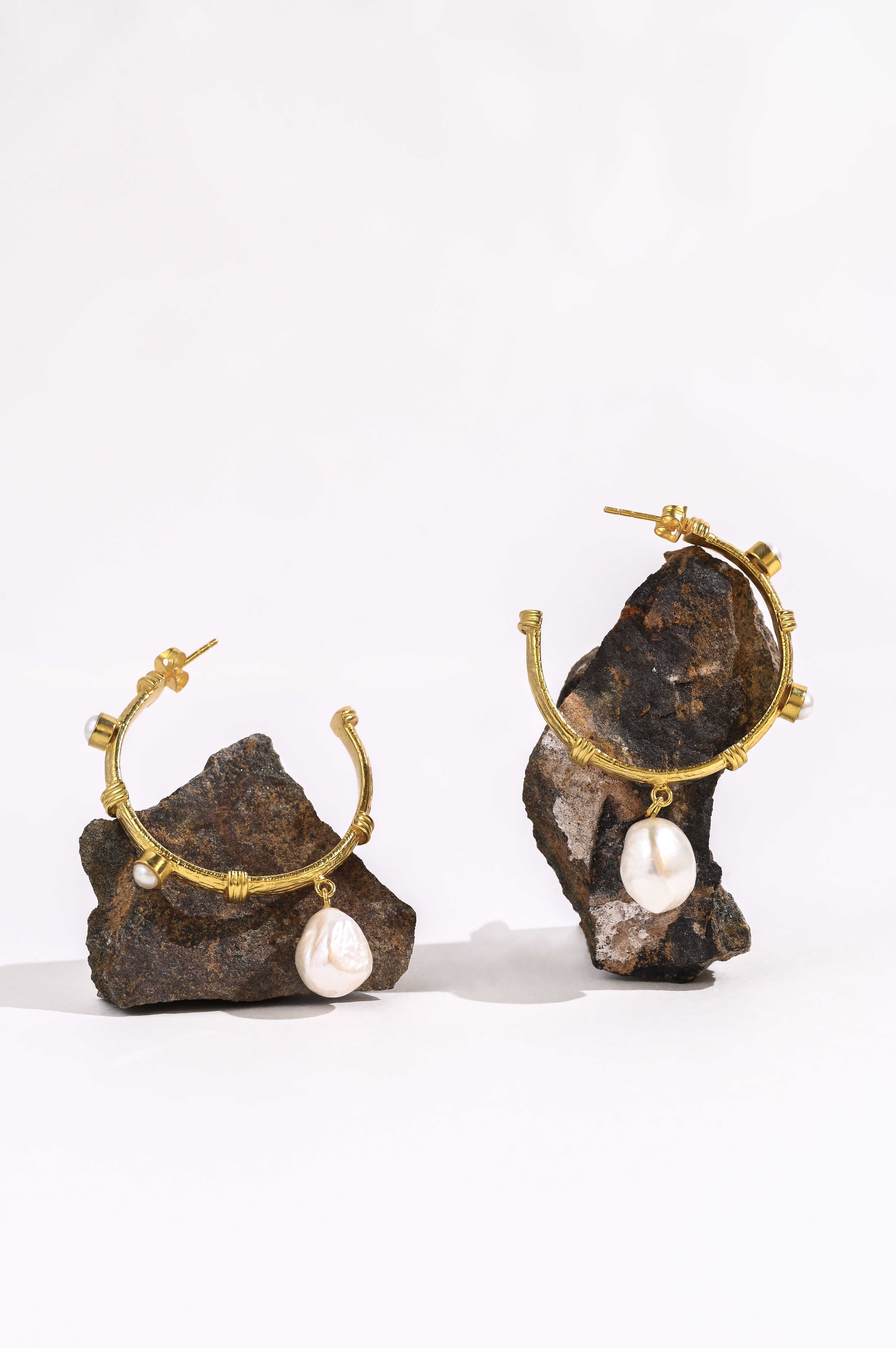 Delicate gold hoop earring adorned with tiny, evenly spaced pearls, creating a subtle and elegant studded effect