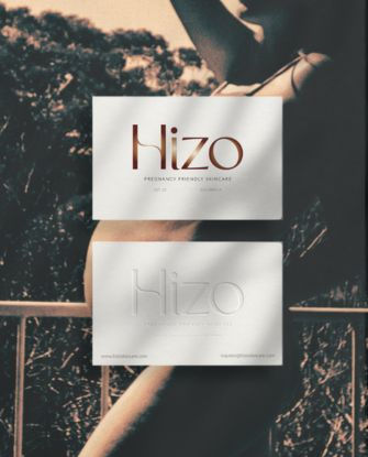 Two business card mockup for Hizo Skincare over image of cool, modern pregnant woman.