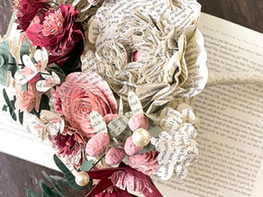 blush and burgundy book page bridal bouquet on top of an open book