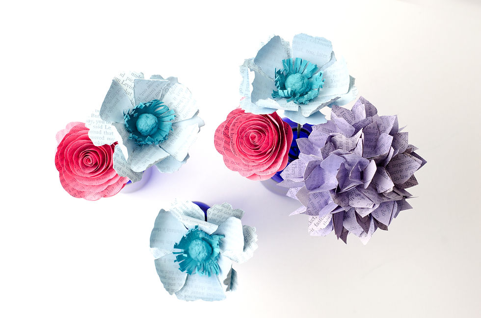 Thumbnail: Top view of three vase centerpiece with book page flowers including anemones, roses and hydrangea