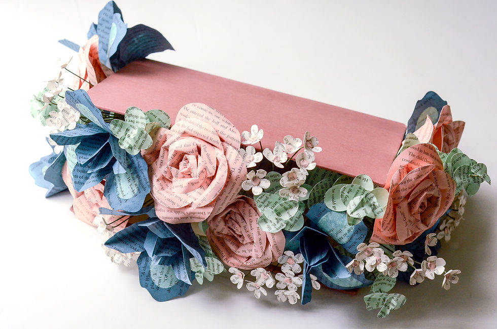 Custom book centerpiece made from the hardcover of an Outlander series book and filled with book page flowers