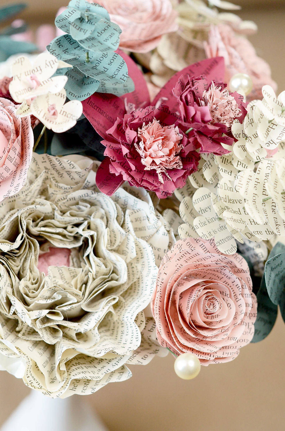 Thumbnail: Close up detail view of a peony, rose, bachelor's buttons, and hawthorne blossoms, all made from book pages
