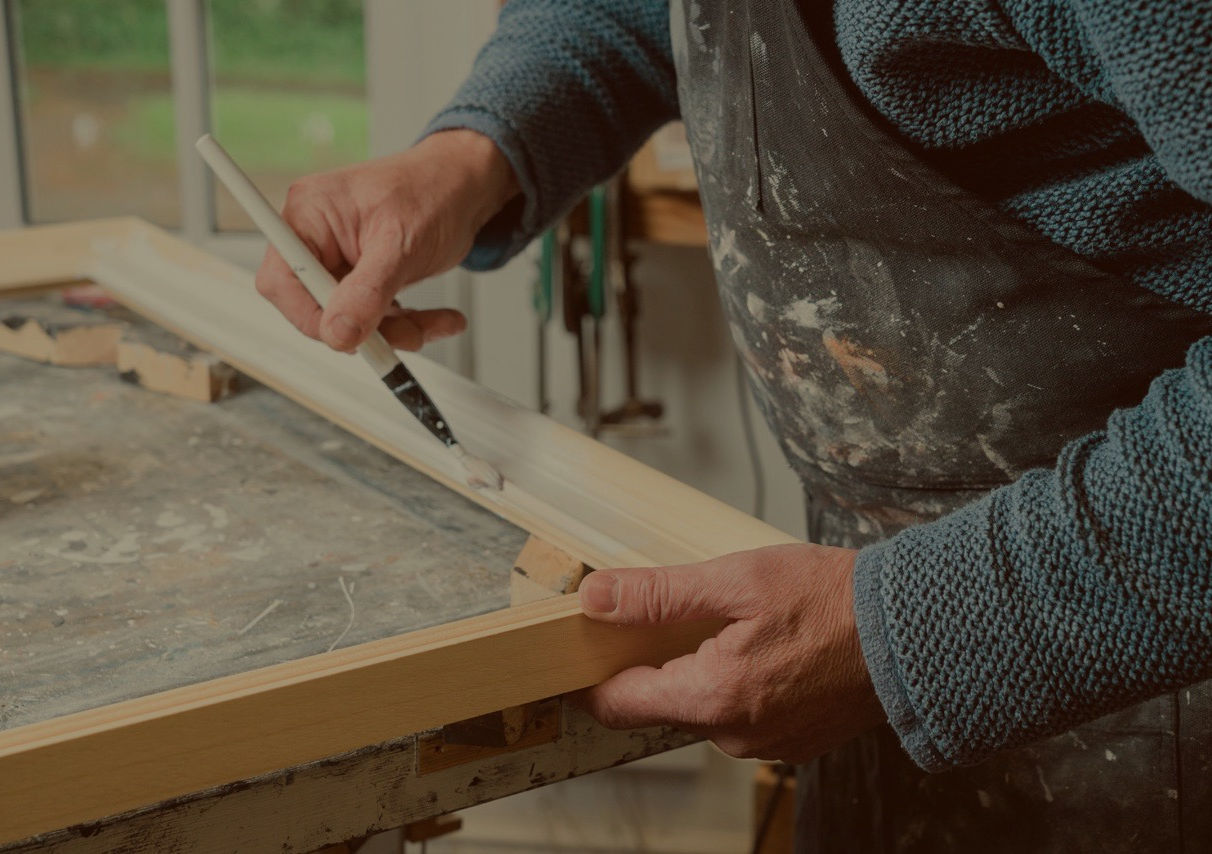 Picture framer hand painting a frame