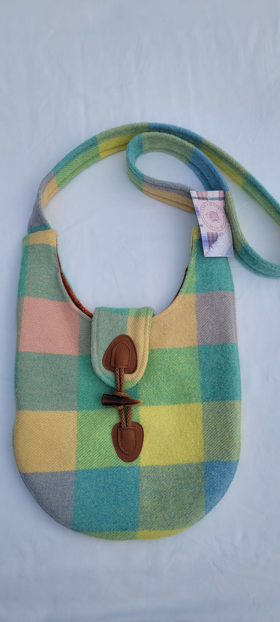 Checked shoulder bag lying flat