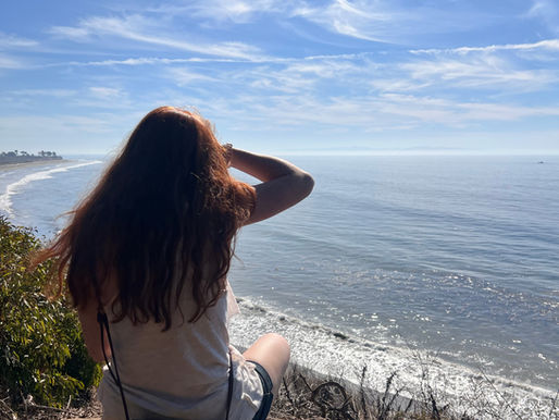 girl looking at distant horizon over shoreline.