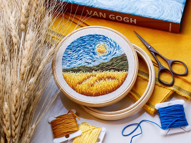 Needle painting embroidery of the Van Gogh starry night, with scissors and thread.