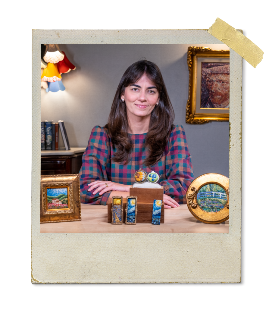 Retrato de Ayeska com modelos de madeira e pinturas em fundo.